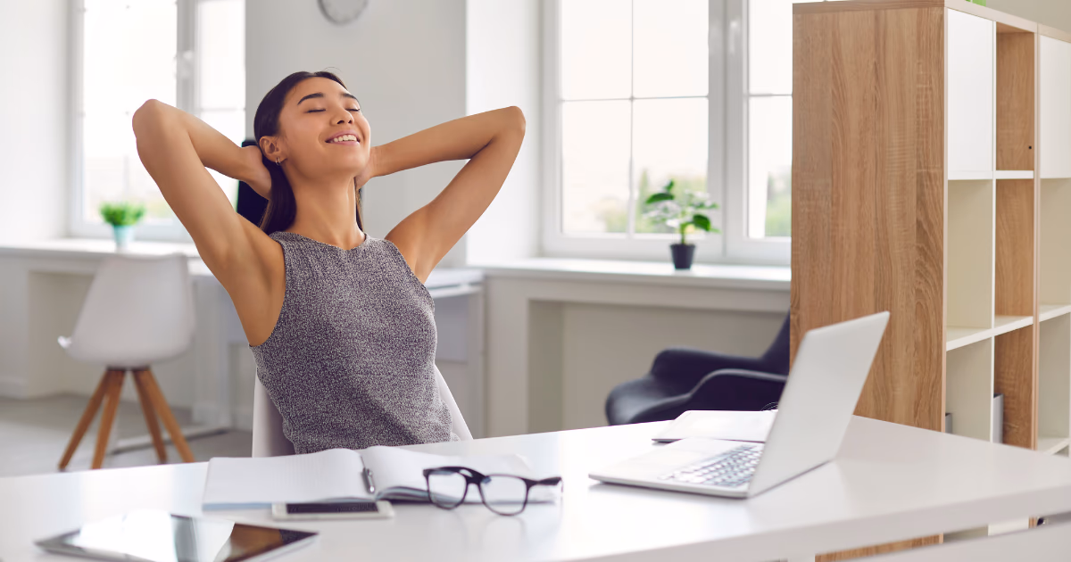 Woman relaxing at desk after completing tasks, illustrating dopamine habits