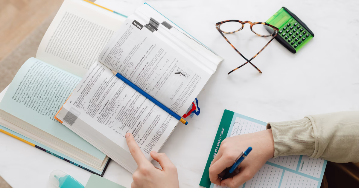 Person taking notes in an open textbook about forming habits psychology, highlighting reinforcement theory and psychological habit loops.